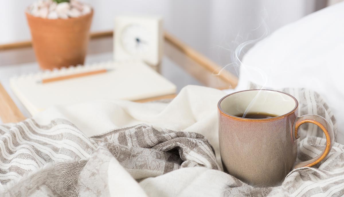 cup-of-coffee-on-cozy-white-bed.jpg