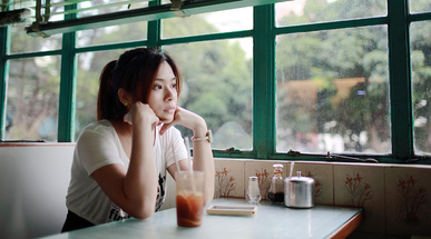 woman-with-hands-on-chin-at-restaurant-table.jpg