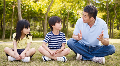asian-father-and-children-talking-in-park.jpg