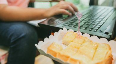 young-woman-eating-seet-food-while-working.jpg