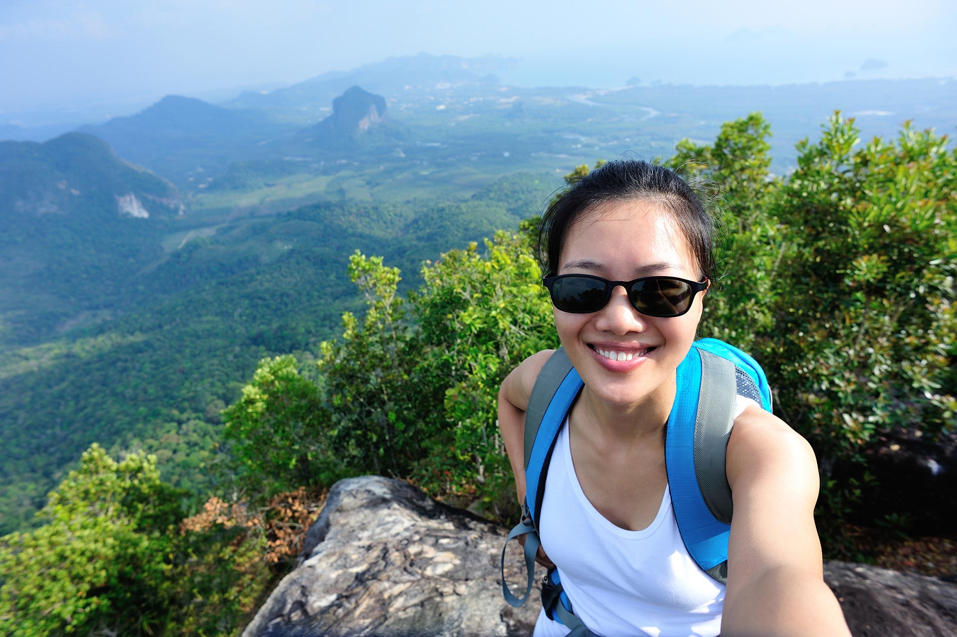 hiking-woman-taking-photo-with-smart-phone-on-mountain-peak.jpg