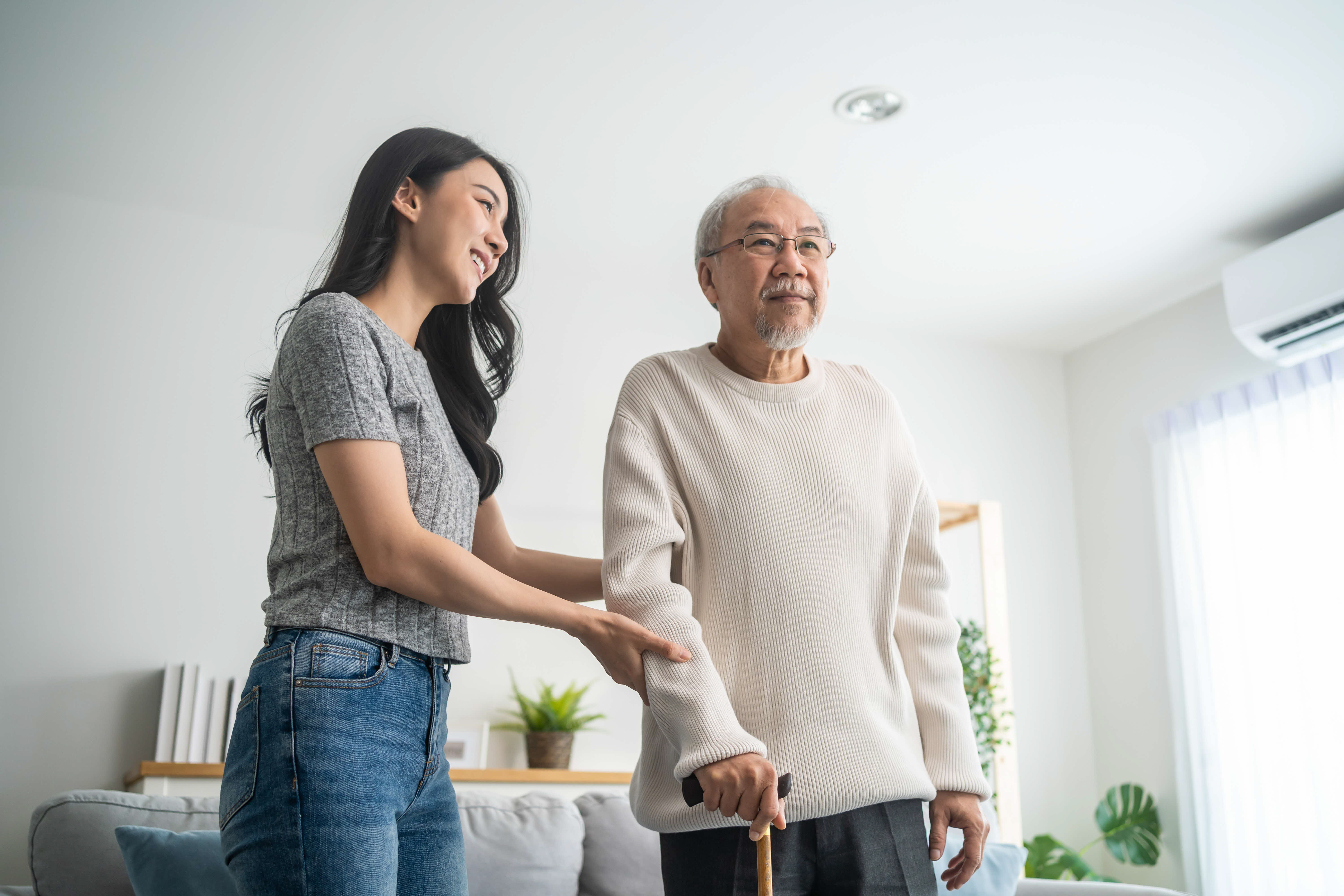 asian-young-daughter-support-senior-older-man-walk-with-walker-home-beautiful-girl-help-take-care-elderly-mature-grandpa-patient-doing-physical-therapy-health-living-room-house.jpg