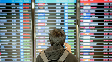 young-asian-man-with-backpack-bag-checking-his-flight-from-the-flight-information-board.jpg