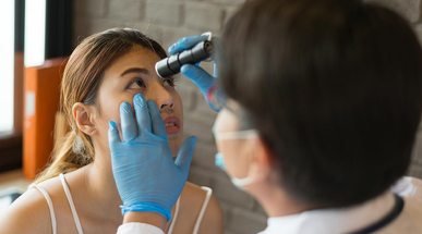 the-doctor-wear-white-coat-shines-a-flashlight-at-the-eyes-of-a-female-patient-at-a-clinic.jpg