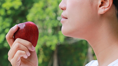 side-view-of-young-asian-girl-eats-an-apple.jpg