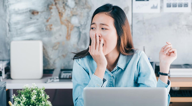 young-asian-casual-business-woman-yawning-at-laptop.jpg