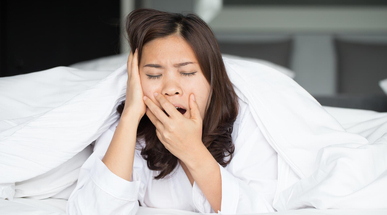 sleepy-asian-woman-yawning-in-bed.jpg